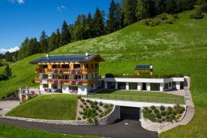 an aerial view of a house with a hill at Apartments La Mana in Santa Cristina in Val Gardena