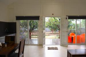 a kitchen with doors open to a patio with orange chairs at Mango Shack Villa in Trimbak