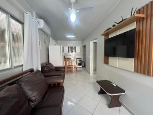 a living room with a couch and a flat screen tv at Residencial Elsa Tarcila in Bombinhas