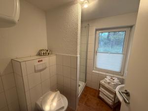 a small bathroom with a toilet and a window at Inselglück unter Reet 100m zum Strand - Garten & Privatterrasse - Hund willkommen in Karlshagen +17 photos