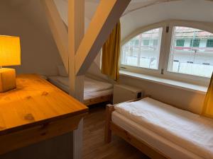 a room with two beds and a table and a window at Inselglück unter Reet 100m zum Strand - Garten & Privatterrasse - Hund willkommen in Karlshagen