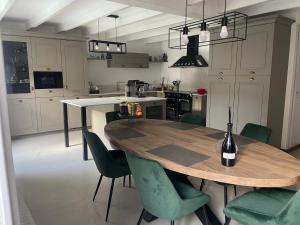 eine Küche mit einem Holztisch und grünen Stühlen in der Unterkunft Ar Gwennili Chambres d'Hôtes 
