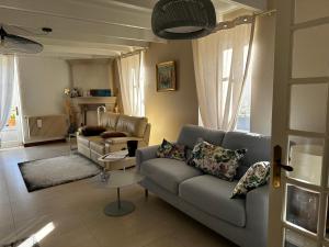 ein Wohnzimmer mit einer Couch und einem Sessel in der Unterkunft Ar Gwennili Chambres d'Hôtes 