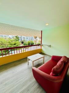 a living room with a red couch and a table at Baan Chanchay Hua Hin in Hua Hin