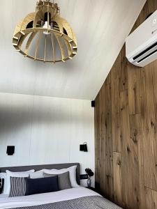 a bedroom with a bed with a wooden wall at Domek Jak z Obrazka in Sierpnica