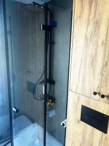 a shower in a bathroom with a glass door at Domek Jak z Obrazka in Sierpnica