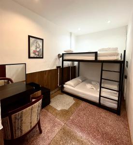 una stanza con due letti a castello e una scrivania di Taladnoi Paint House a Bangkok