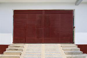 Una gran puerta de madera con escaleras delante. en Hotel O Brij Ghat Mukteshwar Formerly Brijwasi Guest House, en Kankather