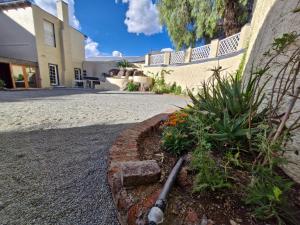 a garden in front of a house with a hose at Coniston Villa in Colesberg