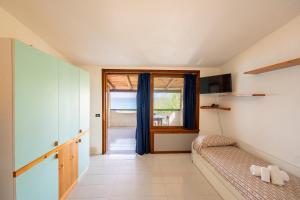 a living room with a couch and a window at Cala Petrosa Resort in Parghelia