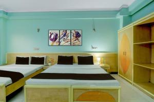 Super Collection O Albert Hall Museum Jaipur Formerly Roop Palace في جايبور: سريرين في غرفة بجدران زرقاء