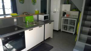 a kitchen with a sink and a microwave at Les Gites de Castera in Aire-sur-lʼAdour