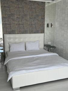 Apart Premium ЖК Андріївський في ترنوبل: غرفة نوم مع سرير أبيض مع اللوح الأمامي الأبيض