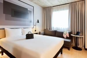 a hotel room with a large bed and a couch at ibis Madrid Norte Las Tablas in Madrid