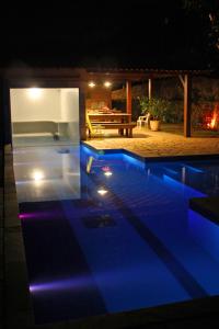 ein Pool mit blauer Beleuchtung in einem Hinterhof in der Nacht in der Unterkunft Pousada Verbicaro in Santa Maria Madalena + 64 Fotos