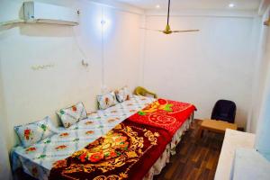 a bedroom with a bed with a red blanket at Radha Krishna Paying Guest House in Ayodhya
