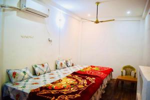 a bedroom with a bed with a red blanket at Radha Krishna Paying Guest House in Ayodhya +8 photos
