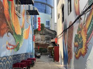 an alley with paintings on the side of a building at Taladnoi Paint House in Bangkok