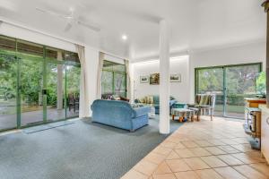 a living room with a blue couch and windows at Tree Elle Retreat in Bow Bridge