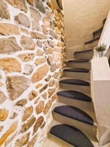 eine Steintreppe in einem Haus mit einer Steinmauer in der Unterkunft L'Occitane Maison de village climatisée in Lapalme