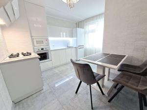 Apart Premium ЖК Андріївський في ترنوبل: مطبخ مع طاولة وكراسي في الغرفة
