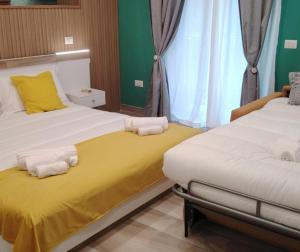 twee bedden in een kamer met gele en groene muren bij Residence Arechi in Salerno