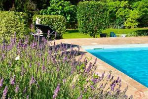 a person sitting in a chair next to a pool at Gîte Studio Les Cigales piscine & WIFI in Narbonne