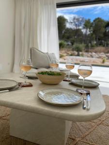 een tafel met glazen wijn en een bord eten bij Casa Bianca - Villa d'architecte avec piscine in Leucate