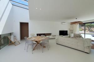 een woonkamer met een tafel en een bank bij Casa Bianca - Villa d'architecte avec piscine in Leucate
