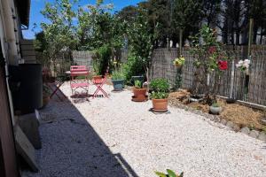 a garden with potted plants and a fence at L'évasion des Corbières in Portel-des-Corbières