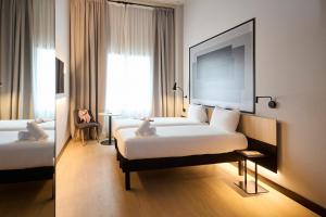 a hotel room with a large bed and a mirror at ibis Madrid Norte Las Tablas in Madrid