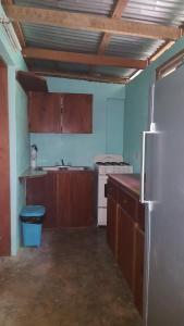 a kitchen with a refrigerator and a sink at Clarissa Falls Resort in San Ignacio