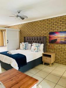 a bedroom with a large bed and a brick wall at St. Lucia Safari Lodge in St Lucia