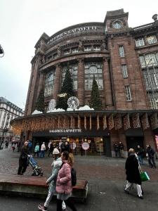 un grupo de personas caminando frente a un edificio en Apparemment 3 pièce Strasbourg Ilkirch graffenstaden, en Illkirch-Graffenstaden