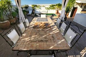 a wooden table and chairs on a patio at Dar Mo'Da in Marrakesh