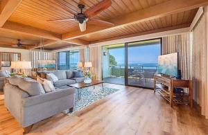 a living room with a couch and a ceiling fan at Coastal Paradise Condo with Panoramic Ocean Views in Kahana