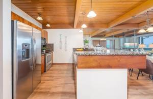 a kitchen with a stainless steel refrigerator and wooden ceilings at Coastal Paradise Condo with Panoramic Ocean Views in Kahana