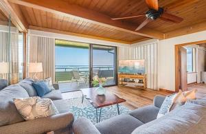 a living room with a couch and a ceiling fan at Coastal Paradise Condo with Panoramic Ocean Views in Kahana +14 photos
