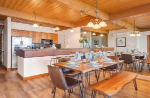 a dining room with tables and chairs and a kitchen at Coastal Paradise Condo with Panoramic Ocean Views in Kahana