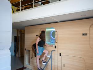 Una mujer entra en un vestuario en Capsule Hotel Happy lounge, en Tiflis