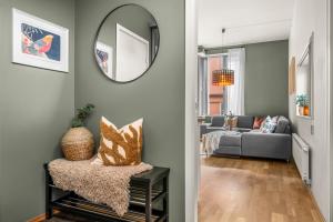 Midtbyen Apartment في تروندهايم: غرفة معيشة مع مرآة وأريكة