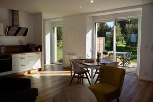 Una cocina y un comedor con mesa y sillas. en La parenthese, en Beaussais sur Mer