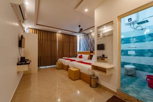 a hotel room with a bed and a large window at Priya Residency Pondicherry in Pondicherry