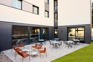 a patio with tables and chairs in front of a building at ibis Madrid Norte Las Tablas in Madrid