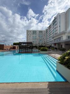 a large blue swimming pool in front of a building at House of Keul - 2BR cozy condo in Dumaguete with pool and free laundry for long term guests up to 4 pax in Piapi