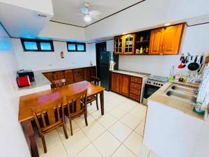 a kitchen with a wooden table and a kitchen with a sink at Oceanfront Scuba Villa in Moalboal