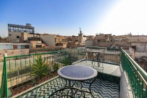 een tafel op een balkon met uitzicht op de stad bij Dar El Kendil in Fès