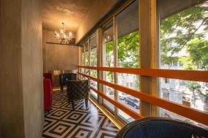 a room with a balcony with a table and windows at Gulf Hotel Mumbai- The Boutique Hotel Colaba Mumbai in Mumbai