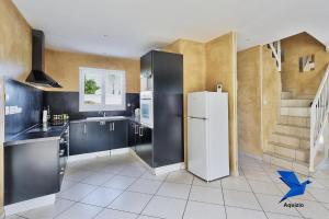 a kitchen with a white refrigerator and a staircase at Belle Maison-St Exupéry- Groupama stadium-Viarhona-T3 in Jons