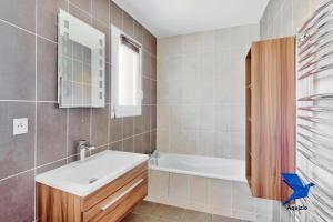 a bathroom with a white sink and a bath tub at Belle Maison-St Exupéry- Groupama stadium-Viarhona-T3 in Jons